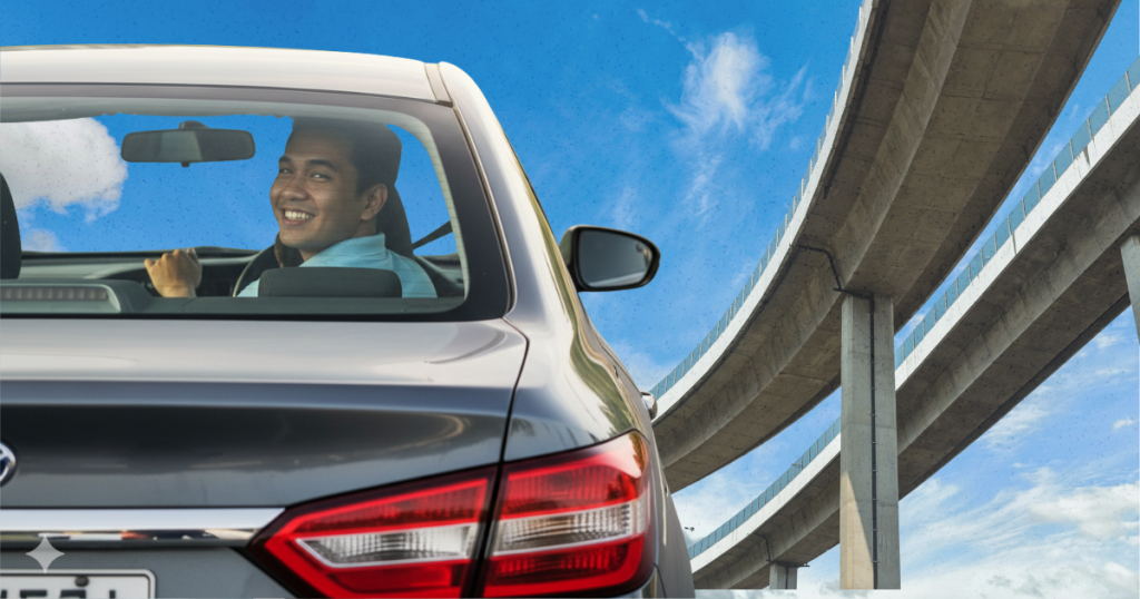 A happy driver in Metro Manila looks over his shoulder inside his car as he drives under a newly constructed elevated road.